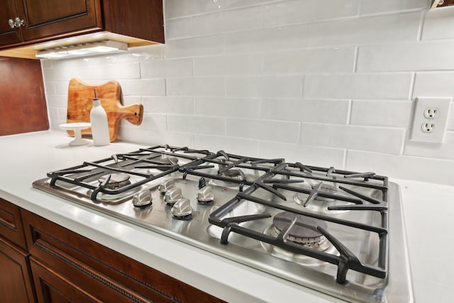 interior details with backsplash and stainless steel gas cooktop