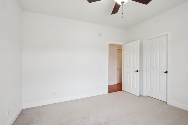 carpeted spare room featuring ceiling fan