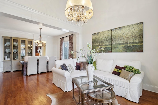 living room featuring an inviting chandelier, crown molding, and dark hardwood / wood-style floors