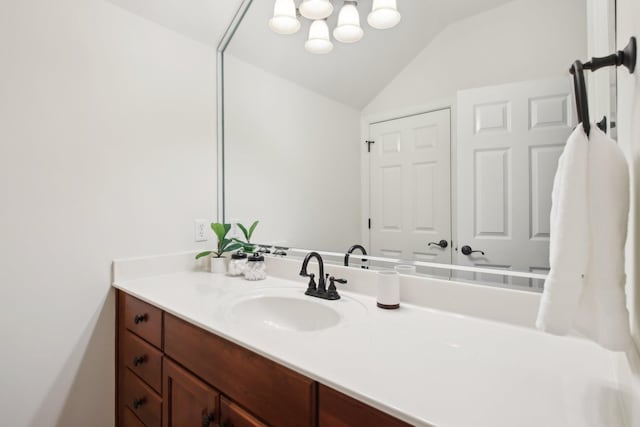 bathroom featuring vanity and lofted ceiling