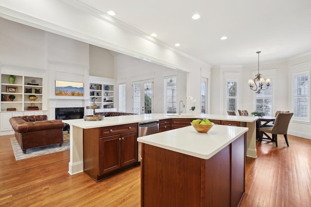 kitchen featuring pendant lighting, ornamental molding, kitchen peninsula, and light hardwood / wood-style floors