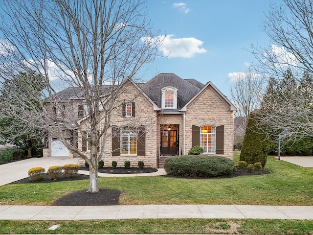 french provincial home featuring a garage and a front yard