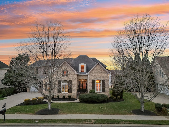 french country home with a garage and a yard