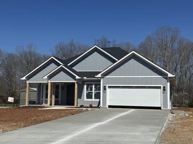 view of front facade with board and batten siding, concrete driveway, an attached garage, and a shingled roof