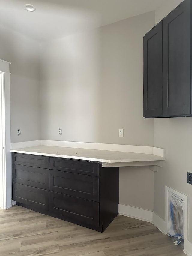 laundry area featuring baseboards and light wood-style floors