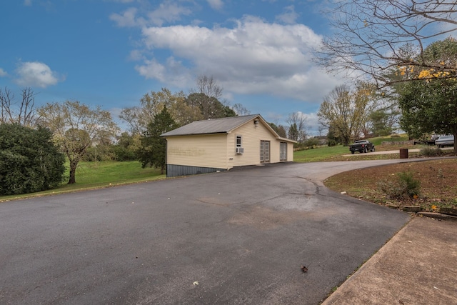 view of property exterior with an outdoor structure and a yard