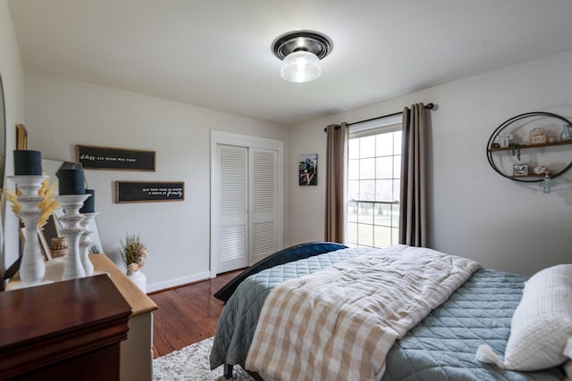 bedroom with dark hardwood / wood-style flooring and a closet