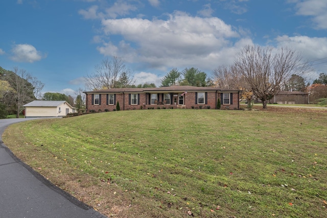 ranch-style home with an outbuilding and a front lawn