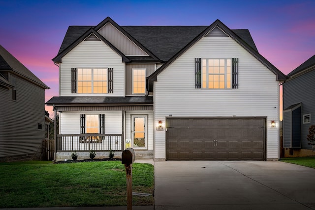 view of front of house with a lawn, a garage, and covered porch