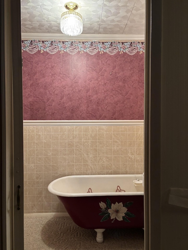 bathroom with a tub and crown molding