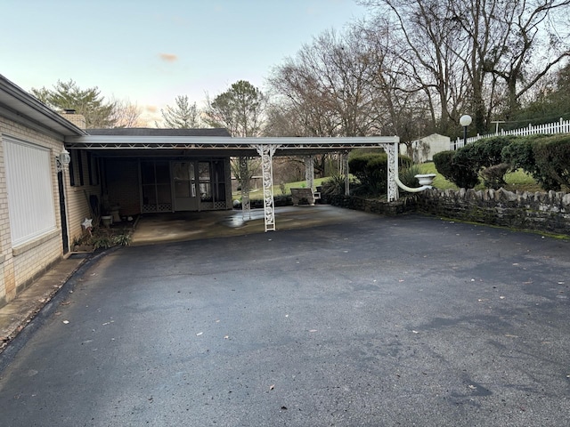 parking at dusk featuring a carport