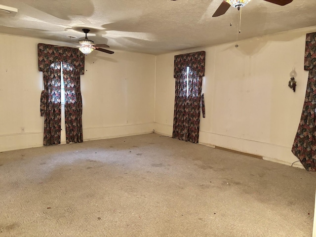 carpeted spare room featuring ceiling fan and a textured ceiling