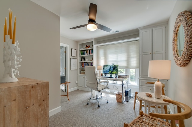 carpeted office space with ceiling fan