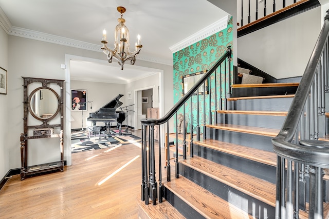 staircase with hardwood / wood-style floors, a chandelier, and ornamental molding