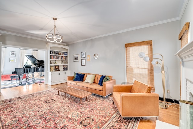 living room featuring an inviting chandelier, ornamental molding, and light hardwood / wood-style flooring