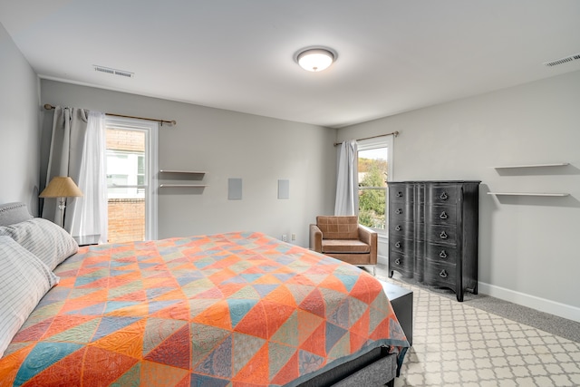 bedroom with light colored carpet and ensuite bathroom