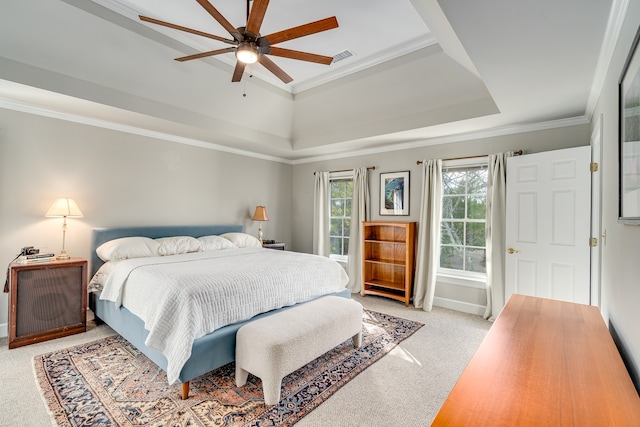 carpeted bedroom featuring ceiling fan, crown molding, and a tray ceiling