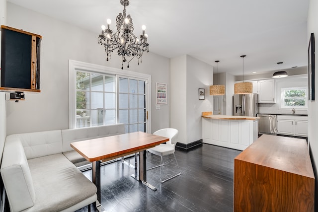 dining space featuring dark hardwood / wood-style flooring, breakfast area, an inviting chandelier, and sink