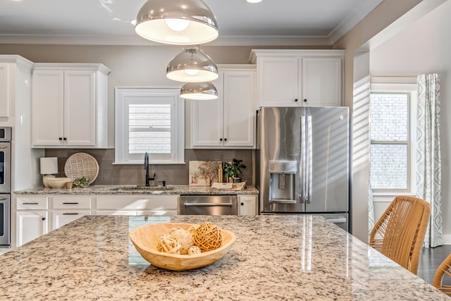 kitchen with white cabinets, sink, light stone countertops, appliances with stainless steel finishes, and tasteful backsplash