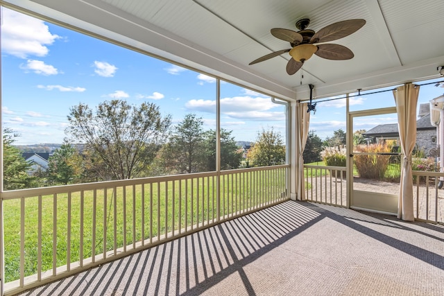 unfurnished sunroom with ceiling fan