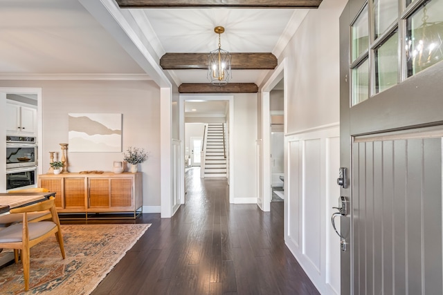 foyer entrance with beamed ceiling, dark wood-type flooring, and ornamental molding