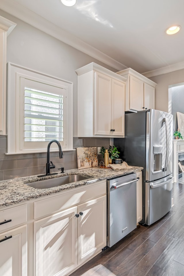 kitchen featuring decorative backsplash, appliances with stainless steel finishes, dark wood-type flooring, sink, and white cabinetry