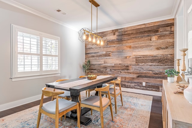 dining room with dark hardwood / wood-style floors, crown molding, and wooden walls