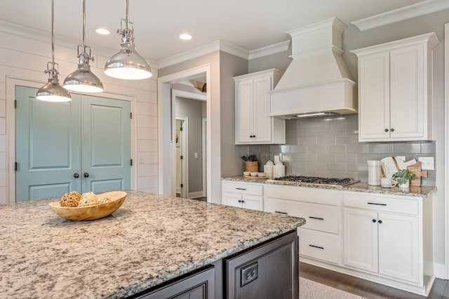 kitchen with pendant lighting, white cabinets, dark hardwood / wood-style flooring, custom range hood, and stainless steel gas cooktop