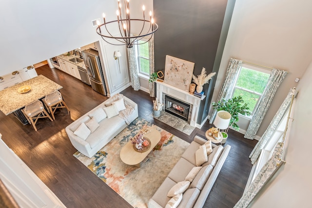 living room with dark hardwood / wood-style floors, a notable chandelier, and sink