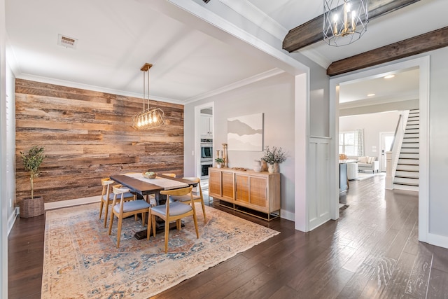 dining space featuring wooden walls, a chandelier, dark hardwood / wood-style floors, and ornamental molding