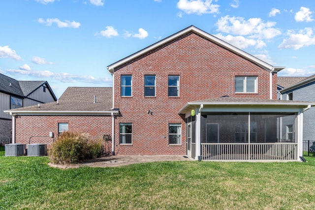 rear view of property with a sunroom, cooling unit, a patio, and a lawn