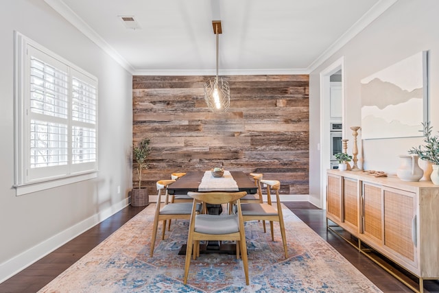 dining space featuring wood walls, crown molding, and dark hardwood / wood-style floors