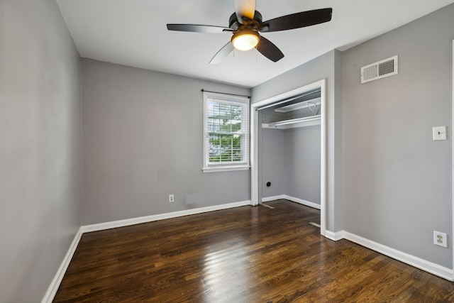 unfurnished bedroom with ceiling fan, dark wood-type flooring, and a closet