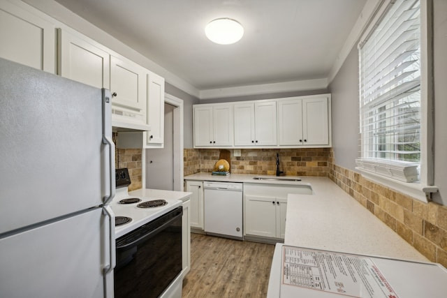 kitchen featuring white appliances, backsplash, premium range hood, white cabinets, and light wood-type flooring