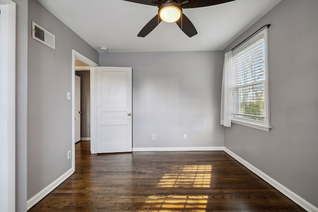 empty room with ceiling fan and dark wood-type flooring