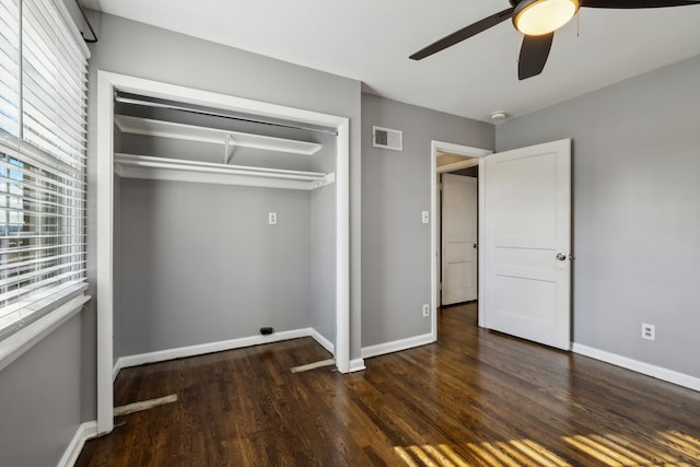 unfurnished bedroom with ceiling fan, a closet, and dark hardwood / wood-style floors