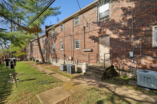 rear view of property featuring a yard and central AC