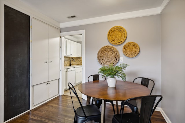 dining space with dark hardwood / wood-style floors and sink