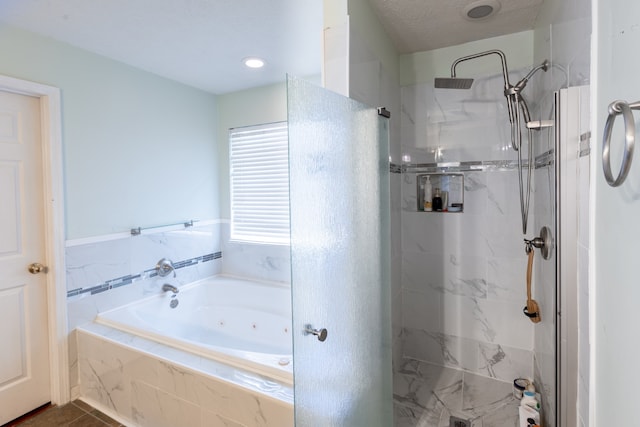 bathroom featuring shower with separate bathtub and a textured ceiling