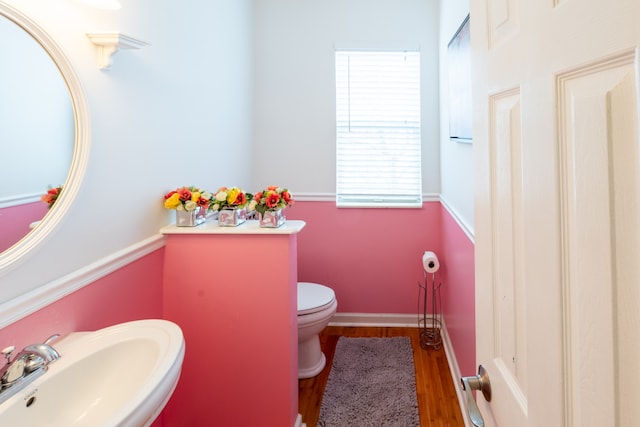 bathroom with hardwood / wood-style flooring, toilet, and sink