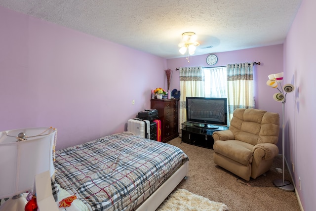 bedroom with a textured ceiling, carpet floors, and ceiling fan