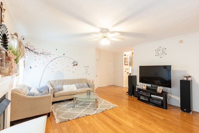 living room featuring ceiling fan, wood-type flooring, and ornamental molding