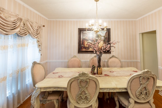 dining room with crown molding, wood-type flooring, and an inviting chandelier