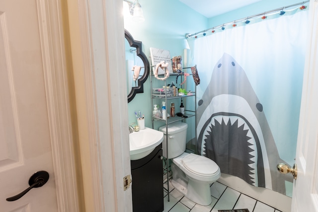 bathroom with toilet, vanity, tile patterned floors, and curtained shower