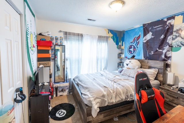 carpeted bedroom with a closet and a textured ceiling