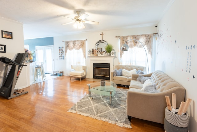 living room featuring crown molding, a healthy amount of sunlight, and wood-type flooring