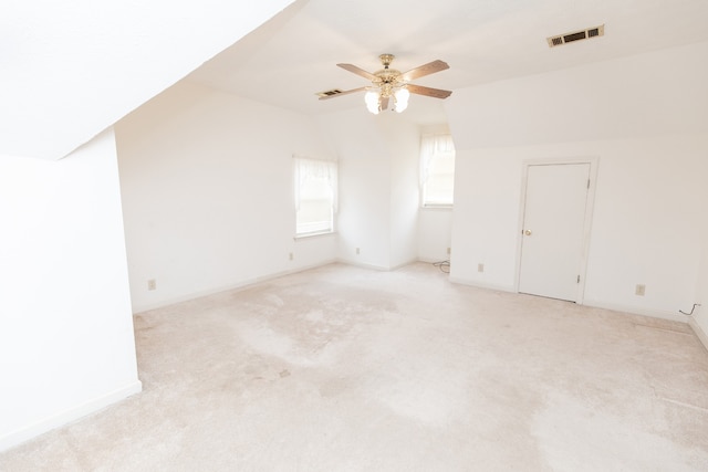 additional living space with ceiling fan, light colored carpet, and lofted ceiling