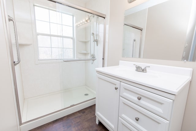 bathroom featuring vanity, wood-type flooring, and walk in shower