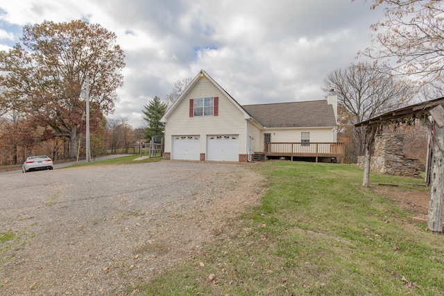 view of front of home featuring a garage, a wooden deck, and a front lawn