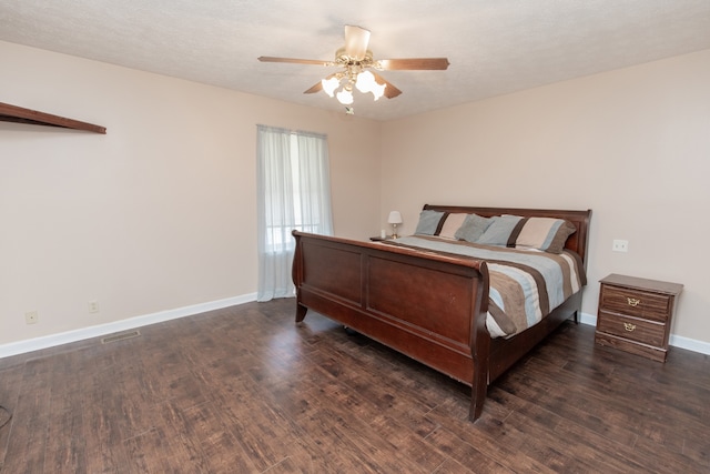 bedroom featuring ceiling fan, dark hardwood / wood-style flooring, and a textured ceiling